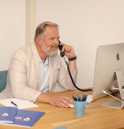 Dennis, makelaar in Castricum, belt vanaf zijn bureau met een klant